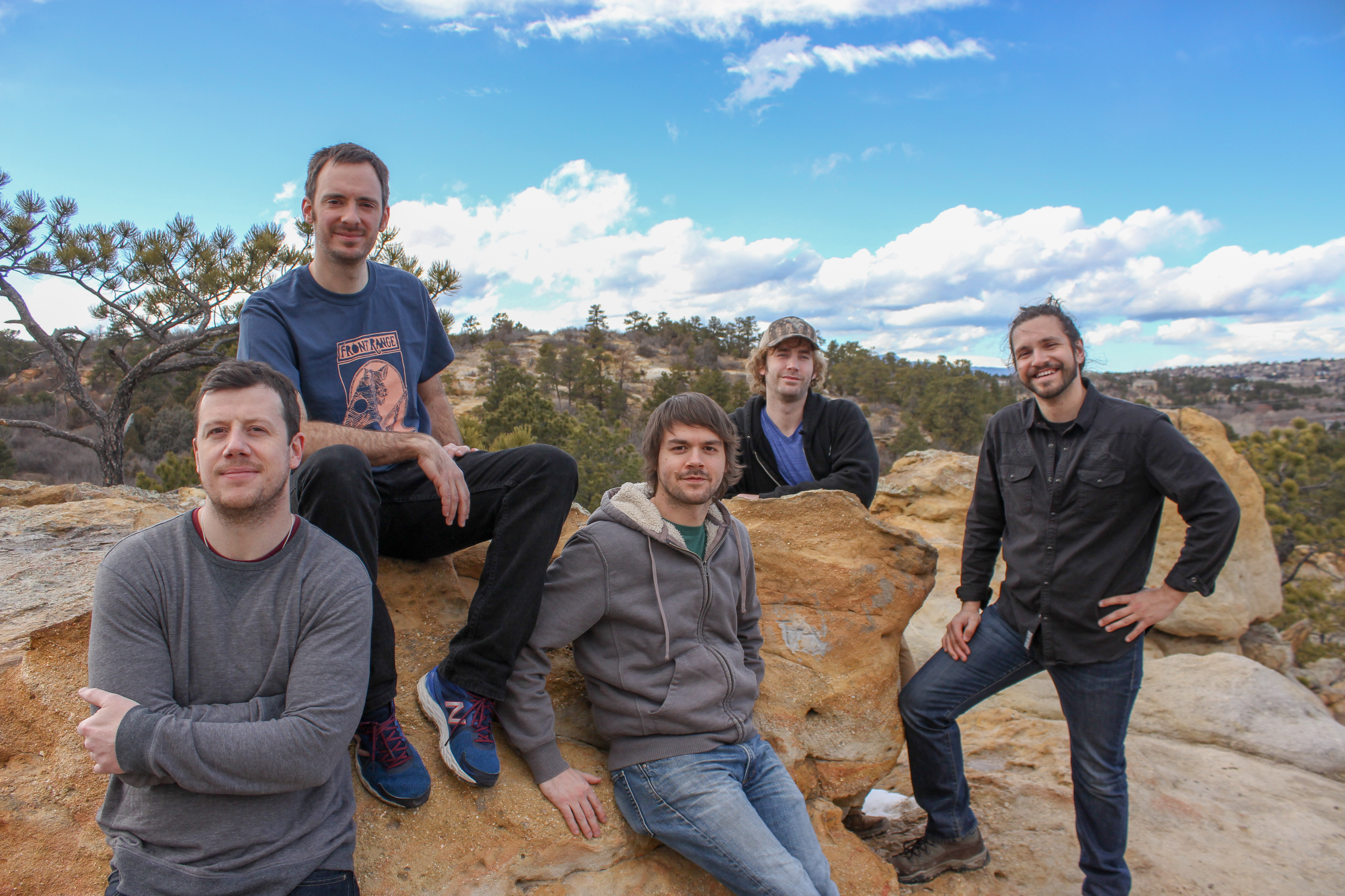 The five members of Fletcher's Grove seated and standing among rocks in Colorado